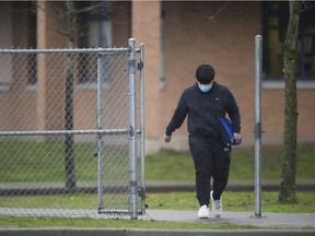 Students wearing masks leave Queen Elizabeth Secondary school in Surrey on February 4, 2021.
