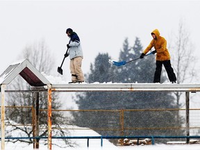 Workers remove snow at Burnaby North Secondary School as another major snowfall is expected in the area.