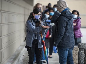 People line up to receive COVID-19 vaccinations at a testing/vaccination centre in Surrey on March 24, 2021.