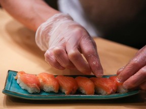 A chef places cuts of salmon onto rice as he prepares a sushi dish. Taiwanese officials urged people to consider the implications before changing their name to "Salmon."