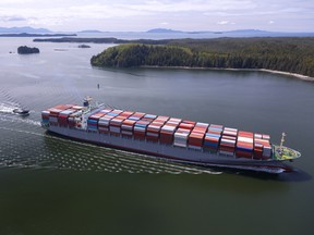 Fully-loaded container ship sails along the coast. SUPPLIED