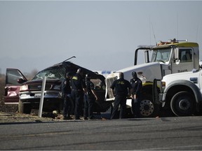 Investagators look over the scene of a crash between an SUV and a semi-truck full of gravel near Holtville, California on March 2, 2021. - At least 13 people were killed in southern California on Tuesday when a vehicle packed with passengers including minors collided with a large truck close to the Mexico border, officials said.