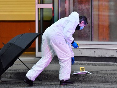 A first responder works at a crime scene where police said multiple people were stabbed by a suspect who was later taken into custody at a public library in the Lynn Valley neighbourhood of North Vancouver, March 27, 2021.