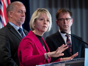 File photo: Provincial health officer Dr. Bonnie Henry responds to questions while B.C. Premier John Horgan, back left, and Health Minister Adrian Dix listen during a news conference about the provincial response to the coronavirus.