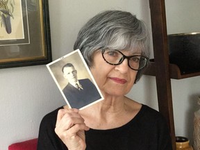 Janette Higgins holds a photo of her late father Jim Higgins.