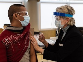 Handout photo of Suni Barstow vaccinating B.C. care aid Edgardo San Jose.