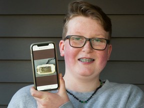 Hunter Hoffman shows a photograph of his lost phone on his replacement phone at his home in Port Coquitlam. Lost while he was rafting on Coquitlam River, it washed ashore on  Mayne Island eight month later.