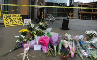 Local residents lay flowers at the scene the day after a mass stabbing that left one person dead at the Lynn Valley Library in North Vancouver.