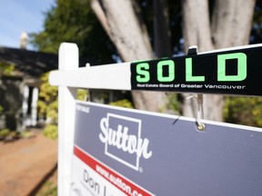 File photo of a sold sign on top of a for sale sign at a home in Vancouver, BC.