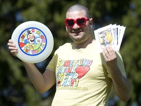 Iven Simonetti holds his branded flying disc and cards that the artist uses in his work as a therapist, in Edmonds Park in Burnaby on April 13.