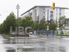 Woman walks in front of UBC sign at the corner of Wesbrook Mall and University Blvd. at UBC on June 2, 2020, for story on classes likely going online this fall due to COVID-19 concerns. Credit: Mike Bell/PNG