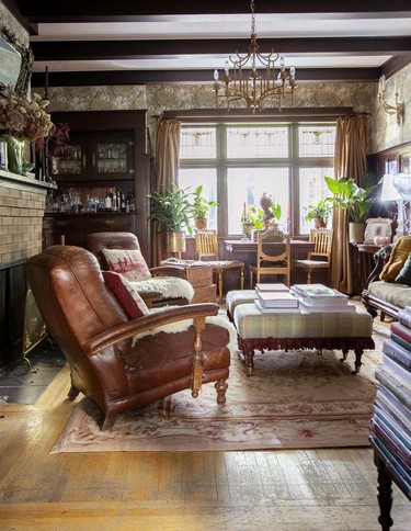 In one of two living rooms, original wood-panelled walls, vintage and contemporary pieces sit together companionably.