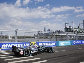 Mitch Evans pilots his Jaguar I-TYPE during the 2019 New York City ePrix in Brooklyn with the Manhattan skyline in the background.