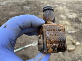 Christian Laub holds a small rye whiskey bottle he dug up on the False Creek Flats.