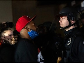 Protestors face off with a line of police officers in front of the Brooklyn Center Police Station after an officer shot and killed a black man in Brooklyn Center, Minneapolis, Minnesota on April 11, 2021.