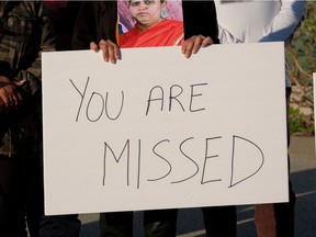 Family members hold photos and signs during a candlelight vigil in Krannert Park in Indianapolis, Indiana, April 17, 2021, to remember the victims of a mass shooting at a local FedEx facility. - A former FedEx employee fatally shot eight people and wounded several others at the delivery company's facility in the US city of Indianapolis before killing himself, authorities said on April 16 after the latest mass shooting to jolt the country.