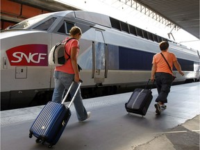 People prepare to board a high-speed train at the Gare St-Charles station in Marseille, southern France.