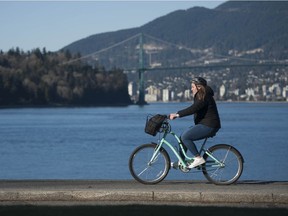 File photo: A cyclist take advantage of the sunny weather in Vancouver.