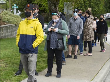 Coquitlam, BC: APRIL 27, 2021 -- Hundreds of people wait in line for a shot of Astra Zeneca Covid-19 vaccine at a Fraser Health pop-up clinic at the Poirier recreation centre in Coquitlam, BC Tuesday, April 27, 2021. People reported waiting in line for more than 2 hours to get their shots.  The line-up snaked around the building.



(Photo by Jason Payne/ PNG)

(For story by reporter) ORG XMIT: covidvaccinepopup [PNG Merlin Archive]