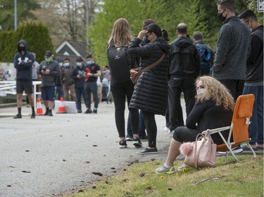 Coquitlam, BC: APRIL 27, 2021 -- Hundreds of people wait in line for a shot of Astra Zeneca Covid-19 vaccine at a Fraser Health pop-up clinic at the Poirier recreation centre in Coquitlam, BC Tuesday, April 27, 2021. People reported waiting in line for more than 2 hours to get their shots.  The line-up snaked around the building.



(Photo by Jason Payne/ PNG)

(For story by reporter) ORG XMIT: covidvaccinepopup [PNG Merlin Archive]