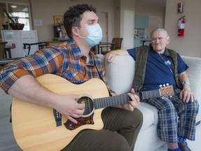 Jack Roche, right, listens to Josh Denny-Keys, a certified music therapist, play and sing My Beautiful Home, Vancouver, which Roche wrote to express his gratitude to staff at St. John Hospice and his love of his adopted hometown.