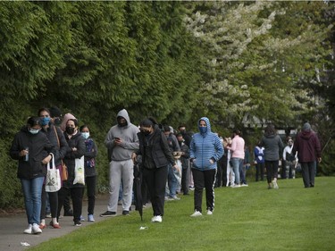 Hundreds of people wait in line for COVID-19 vaccines at a Fraser Health pop-up clinic at the Newton Athletic Park in Surrey on Wednesday, April 28, 2021.