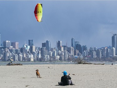VANCOUVER,BC:APRIL 4, 2021 -- A man practices on controlling a kite for kitesurfing while sitting on the sand at Spanish Banks in Vancouver, BC, April, 4, 2021. (Richard Lam/PNG) (For ) 00064274A [PNG Merlin Archive]