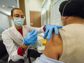 Anastasia Besiou of Wellness Pharmacy Surrey administers a vaccine shot in Surrey, BC, April 13, 2021.