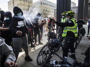 A police officer uses pepper spray on people at a protest in support of the Palestinian people relating to the conflict with Israel. This was at the consulate of Israel in the Westmount area of Montreal Saturday, May 15, 2021.