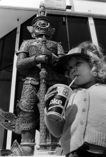 Expo 86 - Pavilions. Pausing for Refresment, Sarah Currie, 4, of Prince George enjoys a soft drink under a Thosakan statue outside the thailand pavilion on the grounds of Expo 86. ran May 6, 1986 pg. A 3 Vancouver Sun. Peter Battistoni Vancouver Sun.  Sunday feature Expo 86 30th anniversary [PNG Merlin Archive]