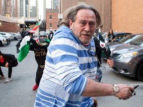 A pro-Israel supporter flees during a brawl with pro-Palestine supporters following a demonstration against the current violence in Gaza in Toronto on Saturday, May 15, 2021.