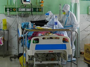 In this picture taken on May 5, 2021, health workers wearing personal protective equipment suits attend to a COVID-19 patient inside the Intensive Care Unit (ICU) of the Teerthanker Mahaveer University (TMU) hospital in Moradabad, India.