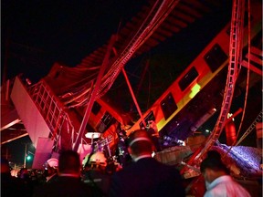 Rescue workers gather at the site of a metro train accident after an overpass for a metro partially collapsed in Mexico City on May 3, 2021. - At least 13 people were killed and dozens injured in a metro train accident in the Mexican capital on May 3, the authorities said.