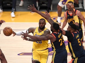 Golden State Warriors forward Draymond Green (23) and center Kevon Looney (5) defend Los Angeles Lakers forward LeBron James (23) under the basket in the second half of the game at Staples Center.