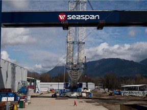A worker walks through the Seaspan Vancouver Shipyards as the main girder of a new 300-tonne gantry crane is lifted into place in North Vancouver.
