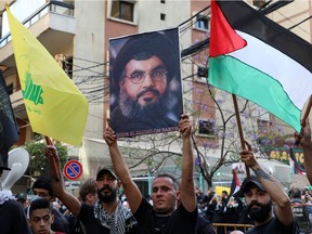 A demonstrator holds a picture of Lebanon's Hezbollah leader Sayyed Hassan Nasrallah during a protest to express solidarity with the Palestinian people, in Beirut suburbs, Lebanon May 17, 2021.