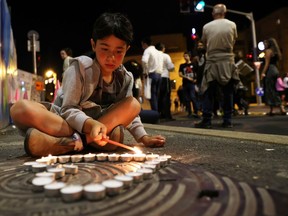 A boy lights candles during a May 1, 2021 vigil in Jerusalem for the people killed and injured in a stampede at an ultra-Orthodox Jewish festival on the slopes of Israel's Mount Meron.