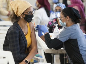 People in the 30-and-older age group receive a COVID-19 vaccination from nurses at the Dukh Nivaran Sahib Gurdwara in Surrey, BC Friday, May 7, 2021.