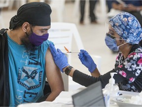 People receive a COVID-19 vaccination from nurses at the Dukh Nivaran Sahib Gurdwara in Surrey on May 7, 2021. The pre-booked appointment-only Fraser Health event administered about 400 Pfizer shots. More events are planned for other high transmission neighbourhoods.