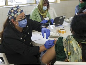 Nurses prepare syringes with Pfizer vaccine as people in the 30-and-older age group receive a Covid-19 vaccination from nurses at the Dukh Nivaran Sahib Gurdwara in Surrey, BC Friday, May 7, 2021.