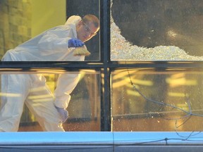Investigators at the scene of shattered glass at Vancouver’s Sheraton Wall Centre in January 2012, where Sandip Duhre was shot and killed while having dinner at the Cafe One Restaurant.