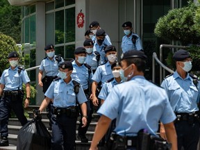 Police carry evidence they sized from the headquarters of the Apple Daily newspaper and its publisher Next Digital Ltd. on June 17, 2021 in Hong Kong, China.