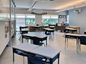 In einem Klassenzimmer der L'Ecole Bilingue im Schulbezirk von Vancouver sind die Schreibtische verteilt und viele Schülerstühle entfernt.  Lehrerin Brianne Fenrich, sitzend.  Obligatorischer Kredit: Schulbezirk Vancouver [PNG Merlin Archive]