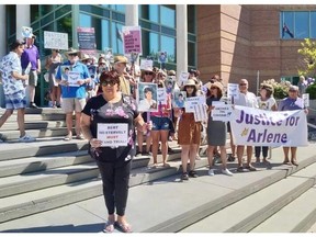 June 26, 2021 - Debbie Hennig, foreground, the sister of Arlene Westervelt, stands in front of a group of friends and family who gathered outside the Kelowna courthouse on Friday. They're calling on the Crown to reactive a murder charge against Westervelt's husband Bert that was stayed last year.