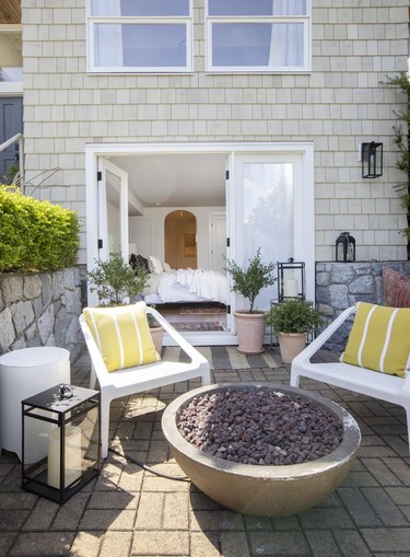 A patio with firepit and sleek seating enters onto the primary bedroom.