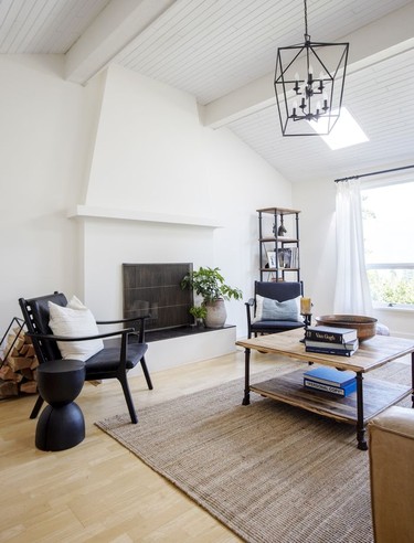 The living room features a wood-burning fireplace and sleek furniture that complements the mid-century lines of the home; accents are in warm earth tones and natural textures.