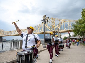 River City Drum Corps marches with a crowd following during the Juneteenth commencement of On the Banks of Freedom on June 19, 2021 in Louisville, Ky.