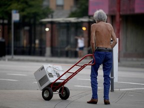 A resident transports an air conditioner on West Pender Street during the heat wave.