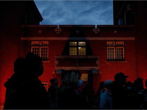 People gather outside the former Kamloops Indian Residential School as they welcome a group of runners from the Syilx Okanagan Nation taking part in The Spirit of Syilx Unity Run, following the discovery of the remains of 215 children buried near the facility, in Kamloops, British Columbia, Canada, on June 5, 2021.