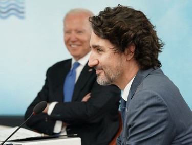 US President Joe Biden (L) and Canada's Prime Minister Justin Trudeau sit around the table at the start of the G7 summit in Carbis Bay, Cornwall on June 11, 2021.